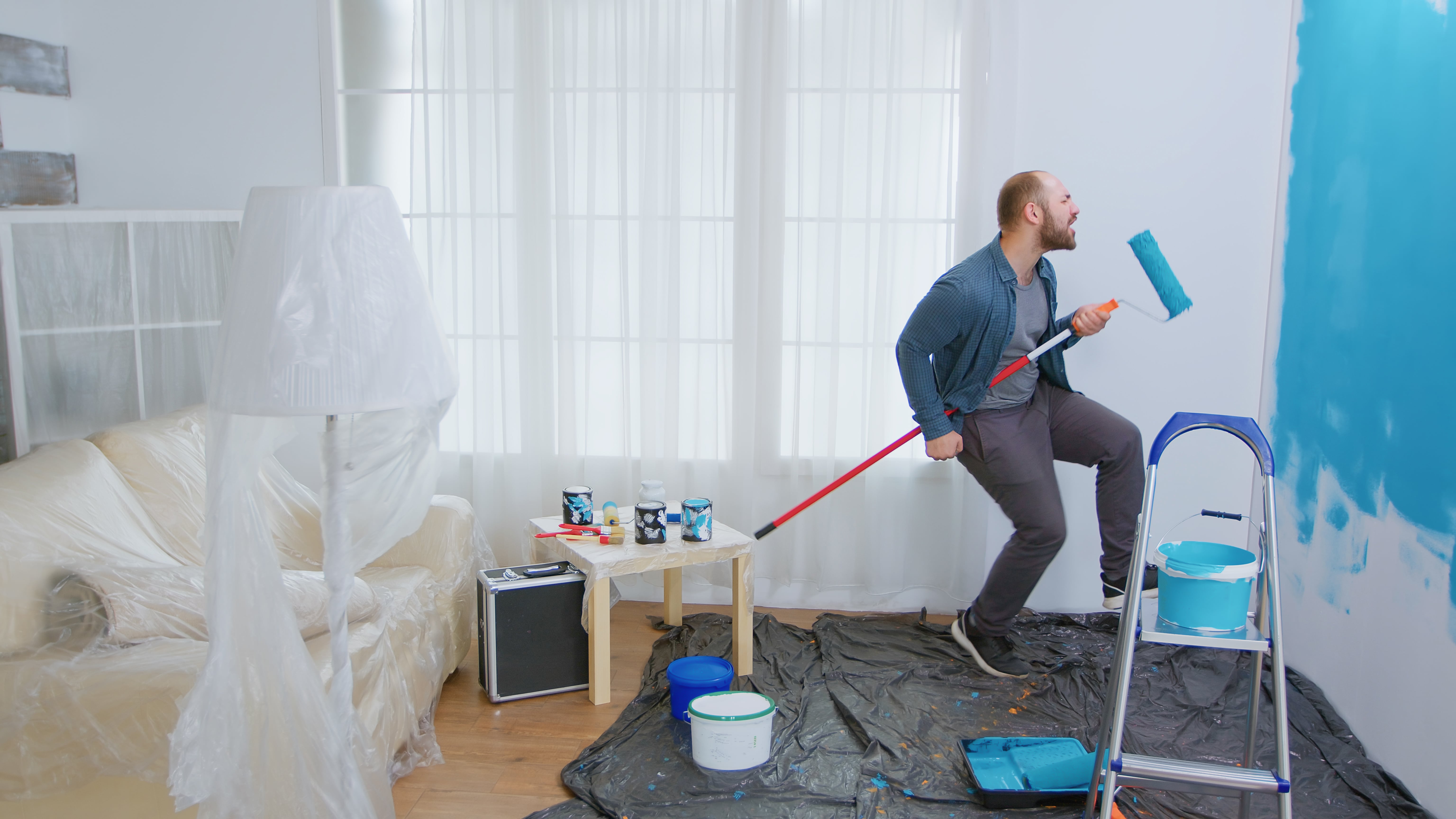 repairman-during-home-construction-using-roller-brush-as-guitar-guy-singing-while-renovating-house-apartment-redecoration-home-construction-while-renovating-improving-repair-decorating-min.jpg